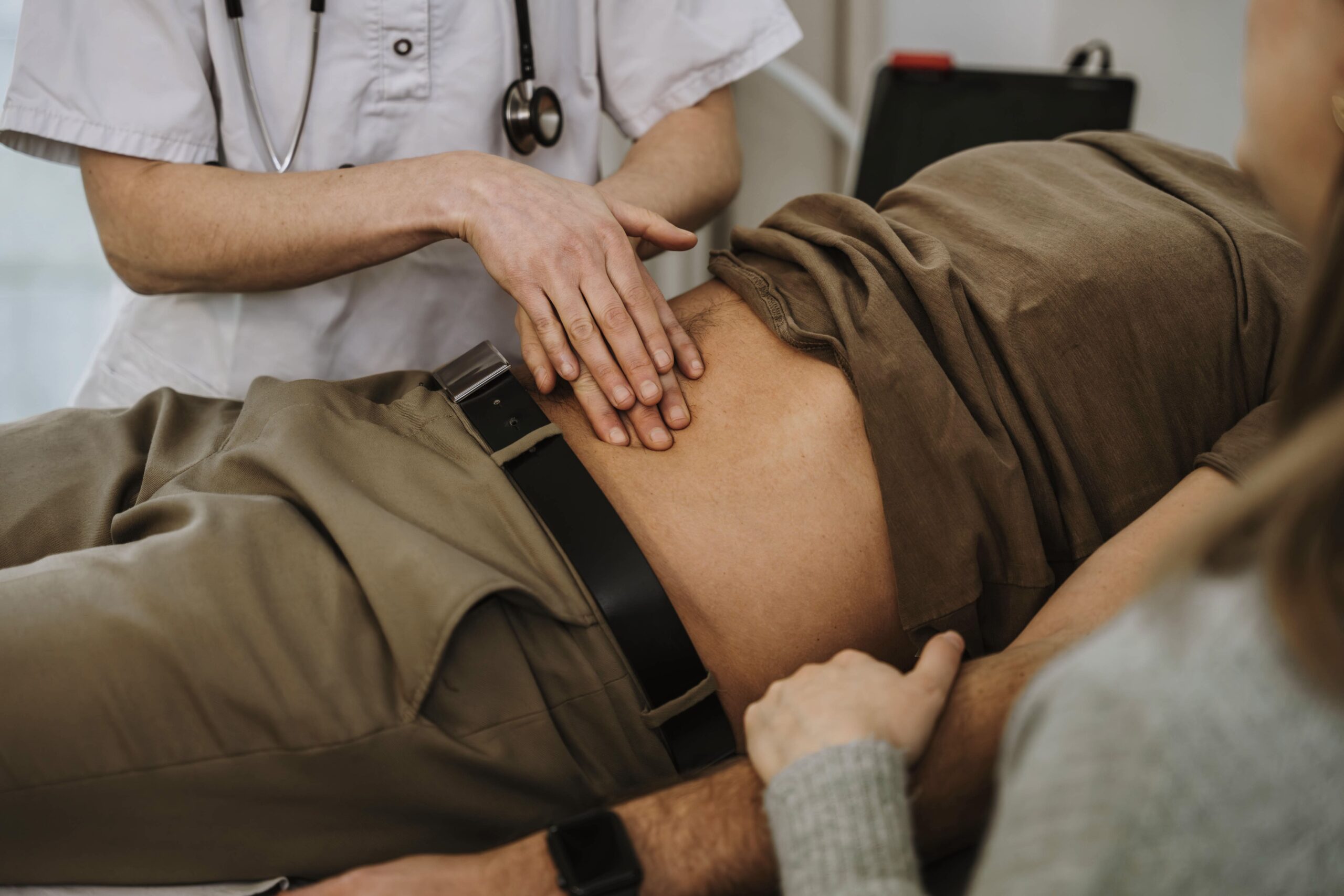 Coloproctología y fisioterapia de suelo pélvico doctor revisando el abdomen de un paciente